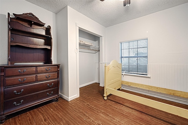 bedroom featuring hardwood / wood-style flooring, ceiling fan, and a textured ceiling