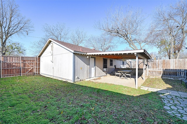 rear view of property featuring a storage shed, a lawn, and a patio area