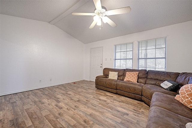 living room featuring a textured ceiling, lofted ceiling with beams, light hardwood / wood-style floors, and ceiling fan