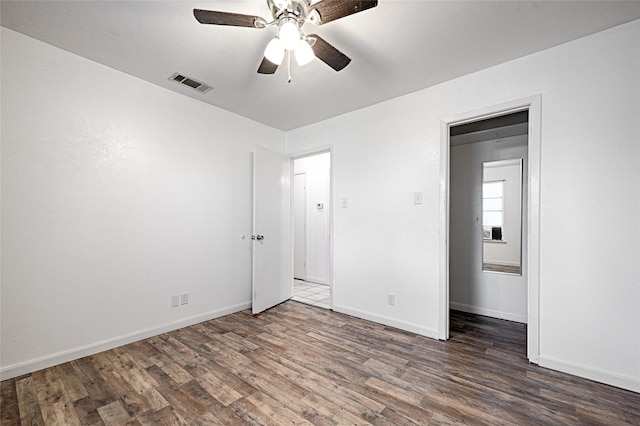 unfurnished bedroom with ceiling fan, a closet, and dark wood-type flooring