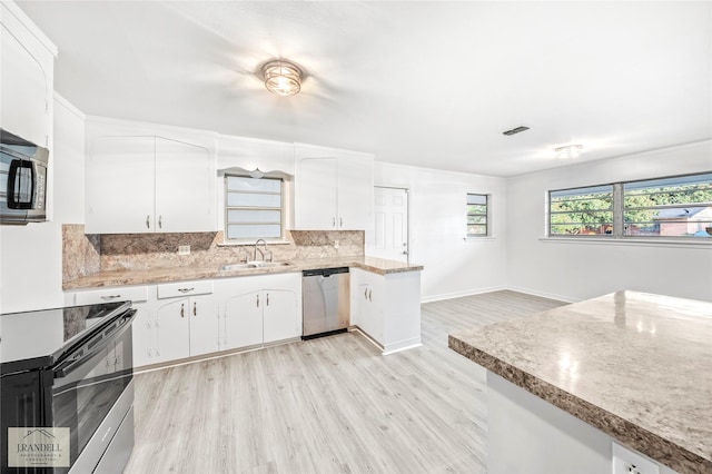 kitchen with white cabinets, appliances with stainless steel finishes, light hardwood / wood-style floors, and sink