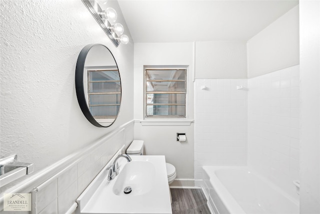 full bathroom featuring hardwood / wood-style flooring, shower / bathtub combination, toilet, and sink