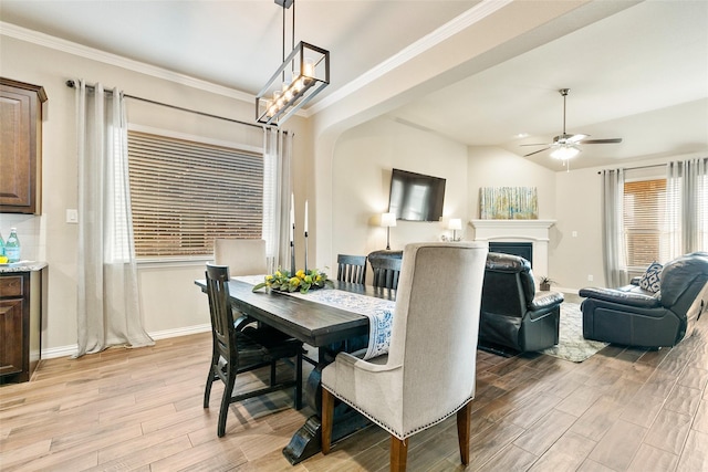 dining space featuring ceiling fan, lofted ceiling, ornamental molding, and light wood-type flooring