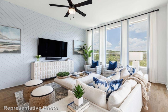 living room with ceiling fan, hardwood / wood-style floors, and wood walls