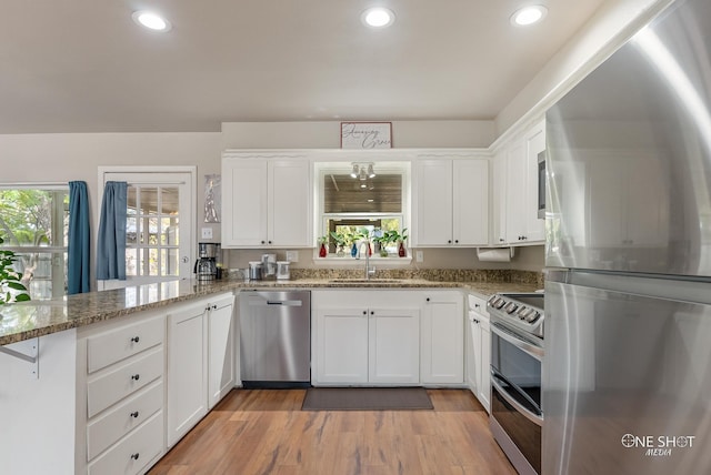 kitchen with plenty of natural light, white cabinetry, stainless steel appliances, and kitchen peninsula