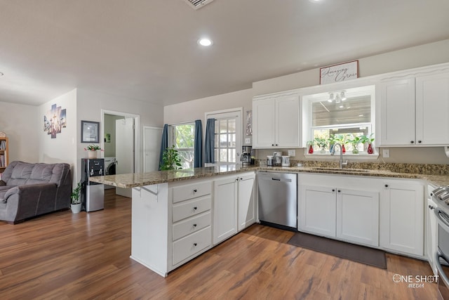 kitchen with white cabinetry, kitchen peninsula, a healthy amount of sunlight, and appliances with stainless steel finishes