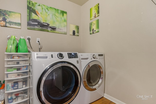 laundry area featuring washer and dryer and light hardwood / wood-style floors