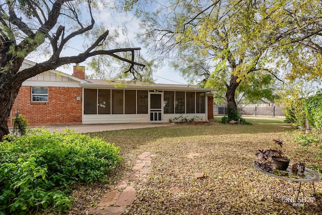 rear view of property with a patio and a sunroom