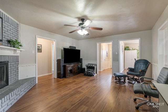 interior space featuring hardwood / wood-style floors, ceiling fan, and a brick fireplace