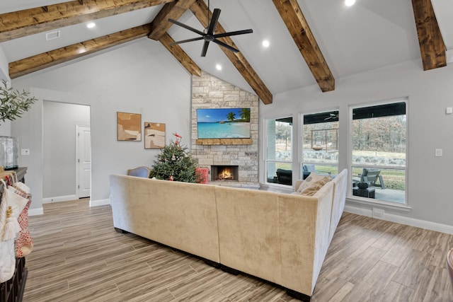 living room with beamed ceiling, ceiling fan, a fireplace, and high vaulted ceiling