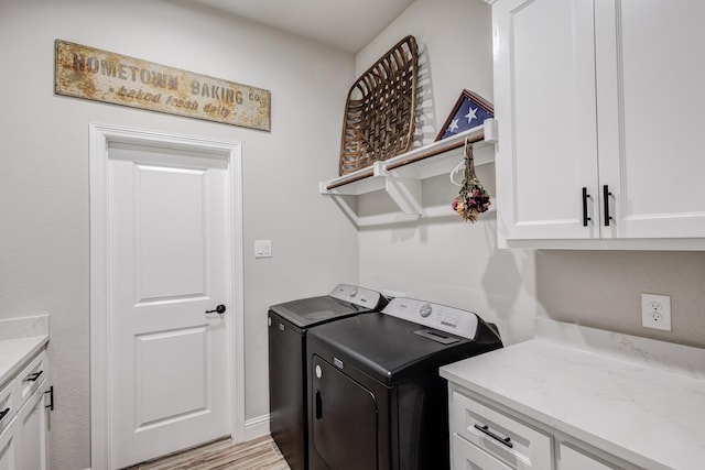 laundry room featuring light hardwood / wood-style floors, cabinets, and independent washer and dryer