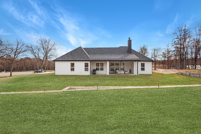 rear view of house featuring a lawn and ceiling fan