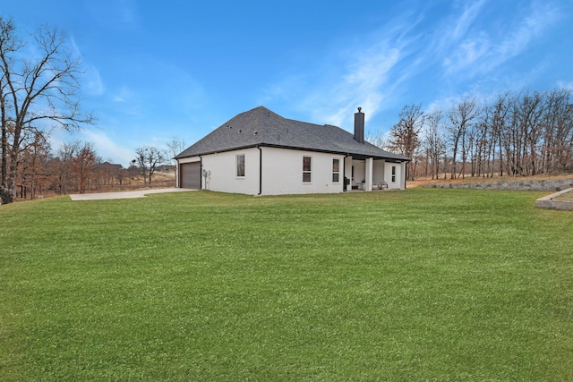 rear view of property with a lawn and a garage