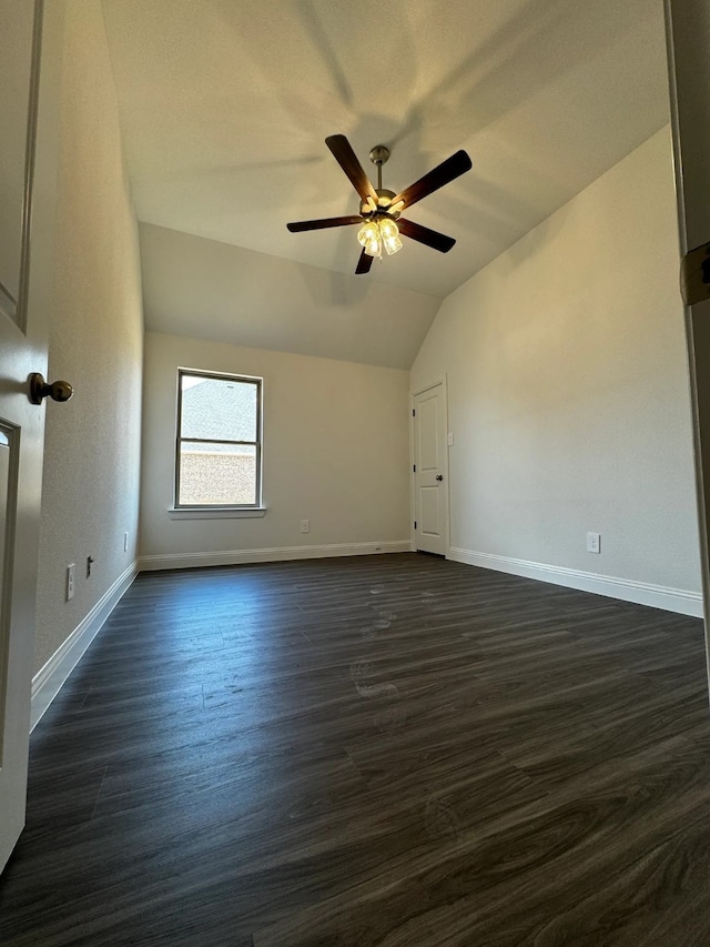 additional living space with ceiling fan, dark hardwood / wood-style flooring, and vaulted ceiling