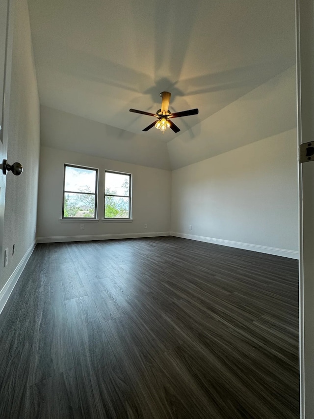 empty room featuring ceiling fan, dark wood-type flooring, and vaulted ceiling