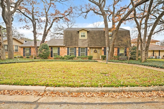 cape cod-style house with a front yard