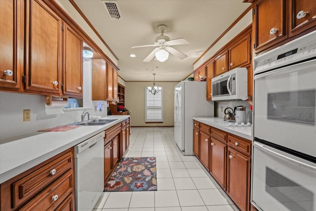 kitchen featuring sink, hanging light fixtures, crown molding, white appliances, and light tile patterned flooring