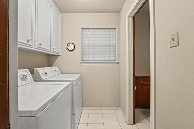 washroom with washer and clothes dryer, light tile patterned floors, and cabinets