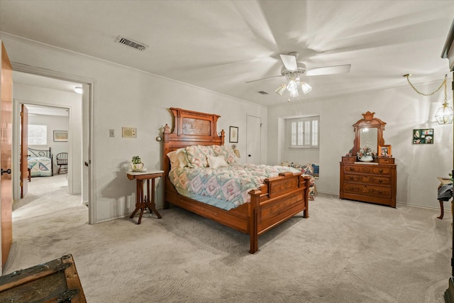 bedroom featuring multiple windows, ceiling fan, and light colored carpet