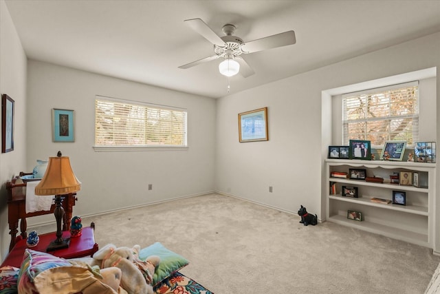 miscellaneous room with ceiling fan and light carpet