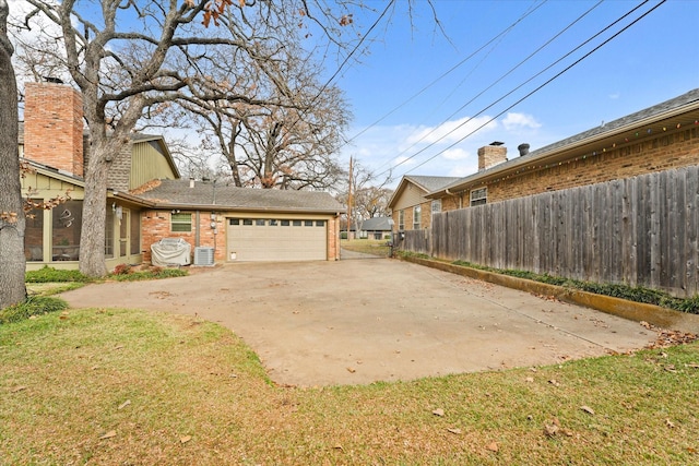 exterior space with central AC and a garage