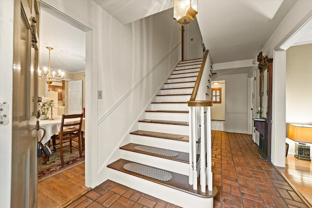 stairway with a notable chandelier