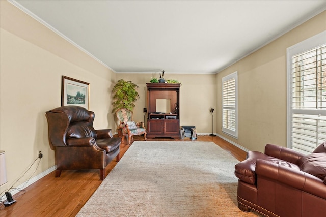 sitting room with hardwood / wood-style floors and crown molding