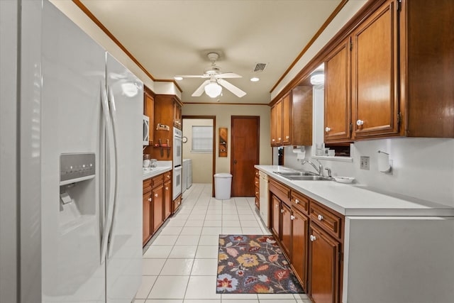 kitchen with ceiling fan, sink, white appliances, light tile patterned floors, and ornamental molding