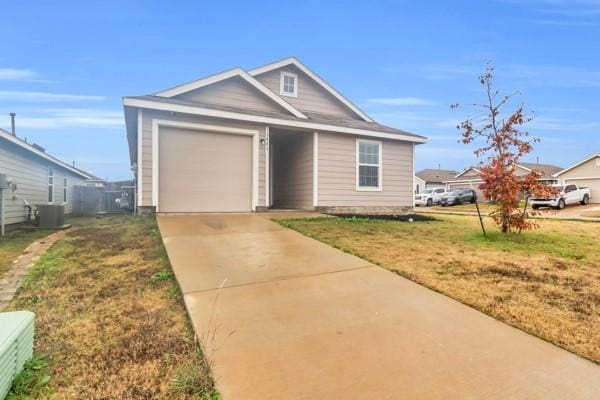 view of front facade with cooling unit, a garage, and a front lawn