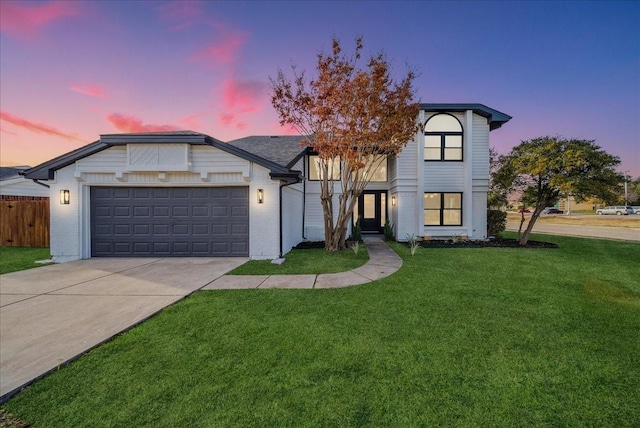 view of front of home with a yard and a garage