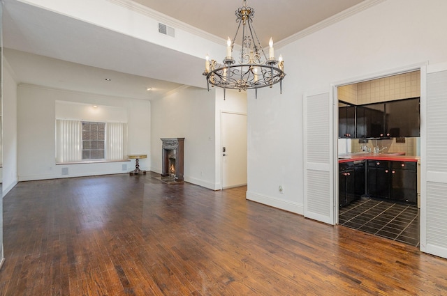 unfurnished living room with dark wood-type flooring, ornamental molding, and a notable chandelier