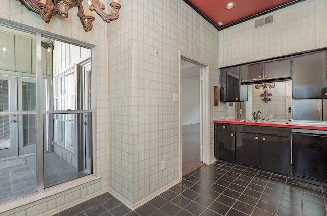 interior space featuring sink, dark tile patterned flooring, dishwasher, and dark brown cabinets