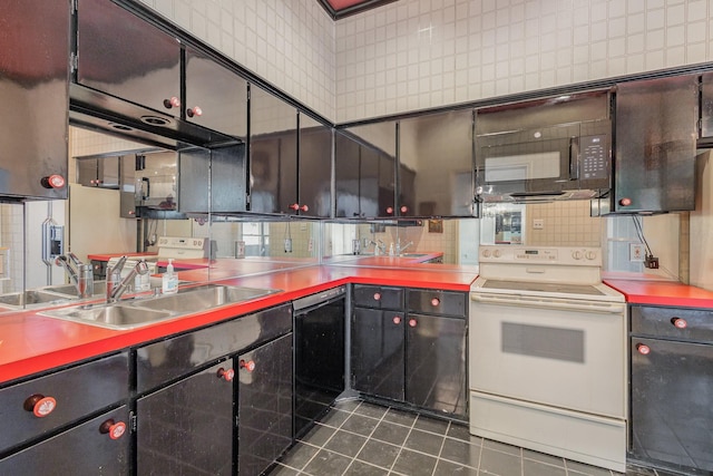 kitchen with sink, dark tile patterned flooring, and black appliances