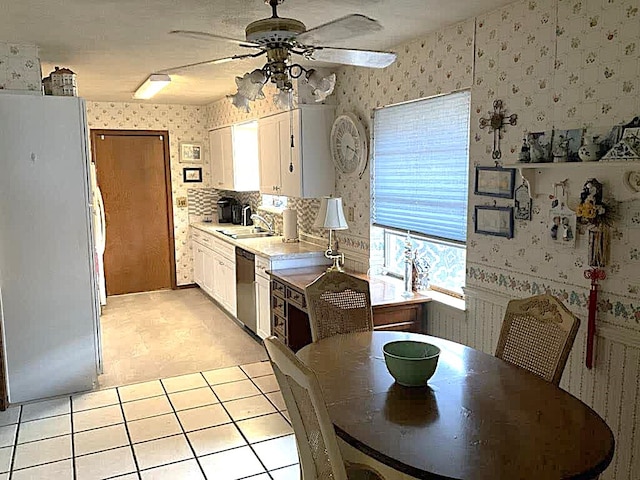 kitchen featuring ceiling fan, sink, fridge, dishwashing machine, and white cabinets