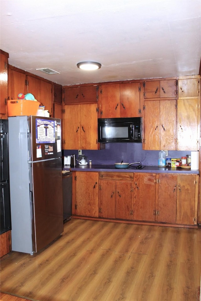 kitchen featuring black appliances and wood-type flooring