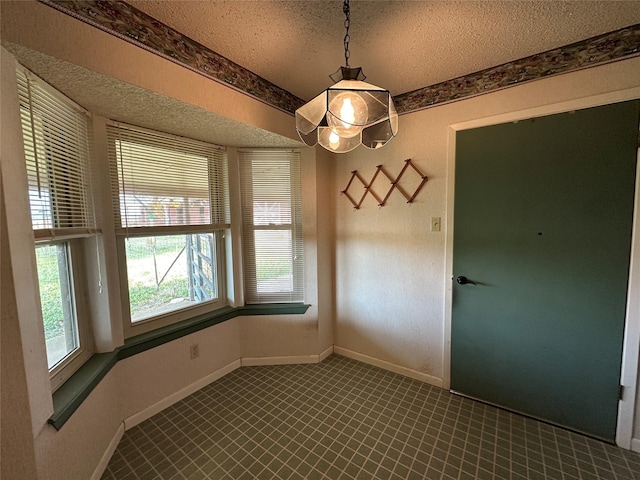 unfurnished dining area with a textured ceiling