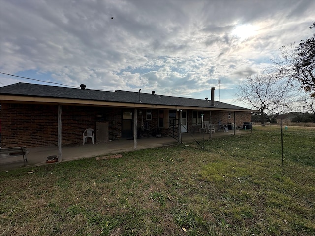 rear view of property with a yard and a patio