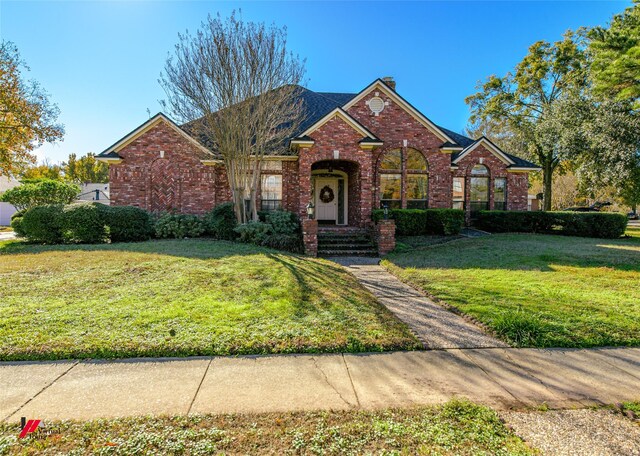 view of front of property with brick siding and a front lawn