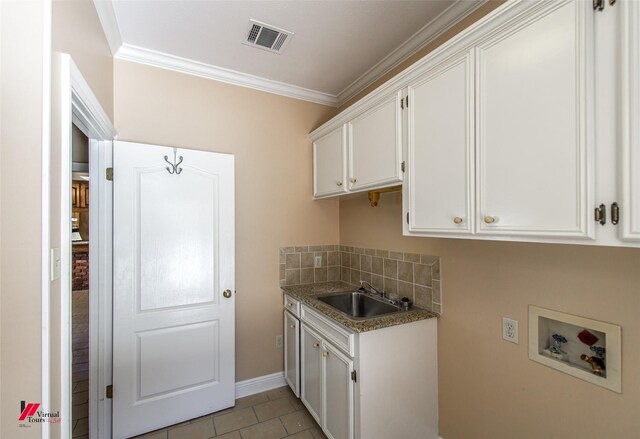 washroom with cabinets, hookup for a washing machine, ornamental molding, and sink