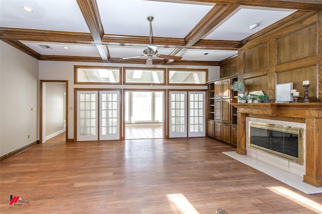 unfurnished living room with hardwood / wood-style floors, coffered ceiling, french doors, ceiling fan, and beam ceiling