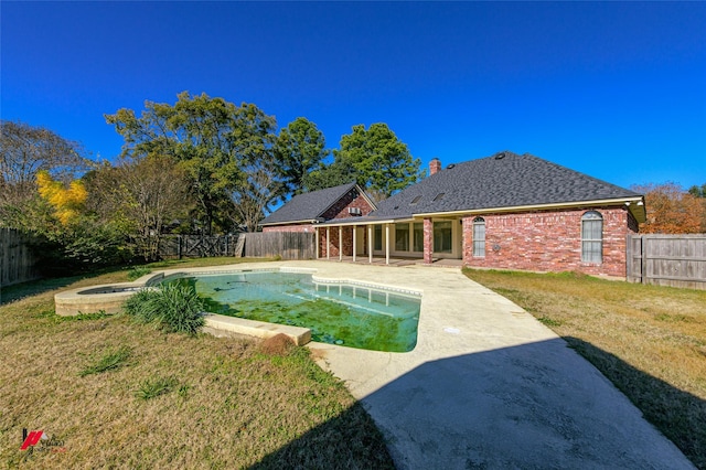 view of swimming pool with a jacuzzi, a yard, and a patio