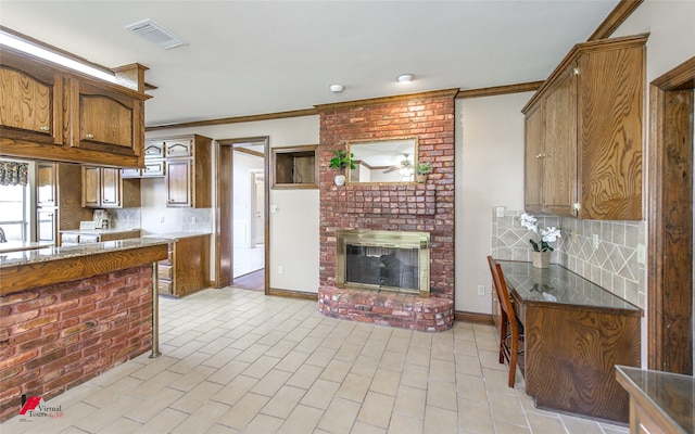 kitchen featuring decorative backsplash, crown molding, and a brick fireplace