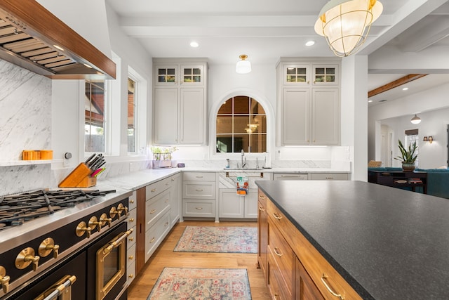 kitchen featuring beam ceiling, white cabinetry, and custom range hood