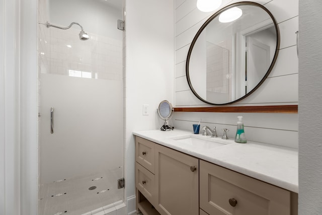 bathroom with a tile shower and vanity