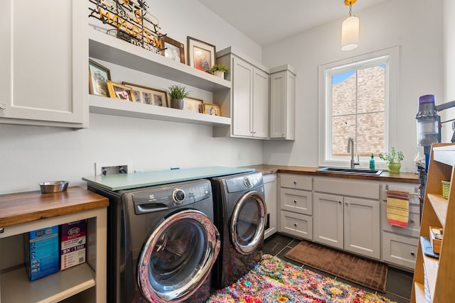 washroom with cabinets, washing machine and dryer, and sink