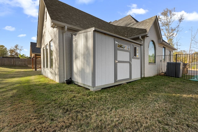 view of side of property featuring a yard and central AC