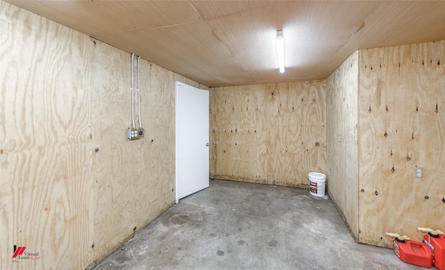 spare room featuring wood ceiling, wooden walls, and concrete floors