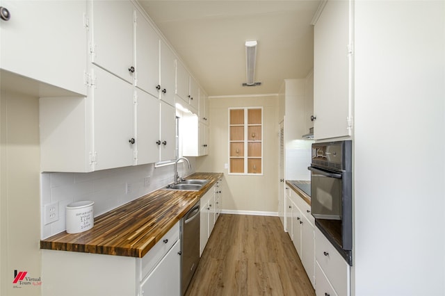 kitchen featuring a sink, black oven, tasteful backsplash, and stainless steel dishwasher