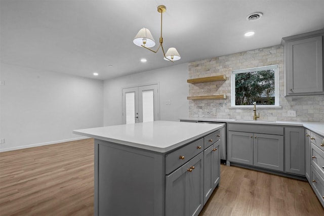 kitchen featuring a center island, sink, light hardwood / wood-style flooring, and gray cabinetry