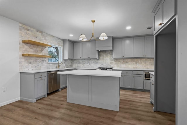 kitchen with a kitchen island, pendant lighting, sink, gray cabinetry, and stainless steel appliances